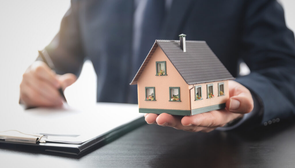 Developers real estate agent is holding a house model